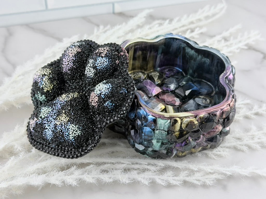 Black and iridescent rhinestone paw print lid viewed from above